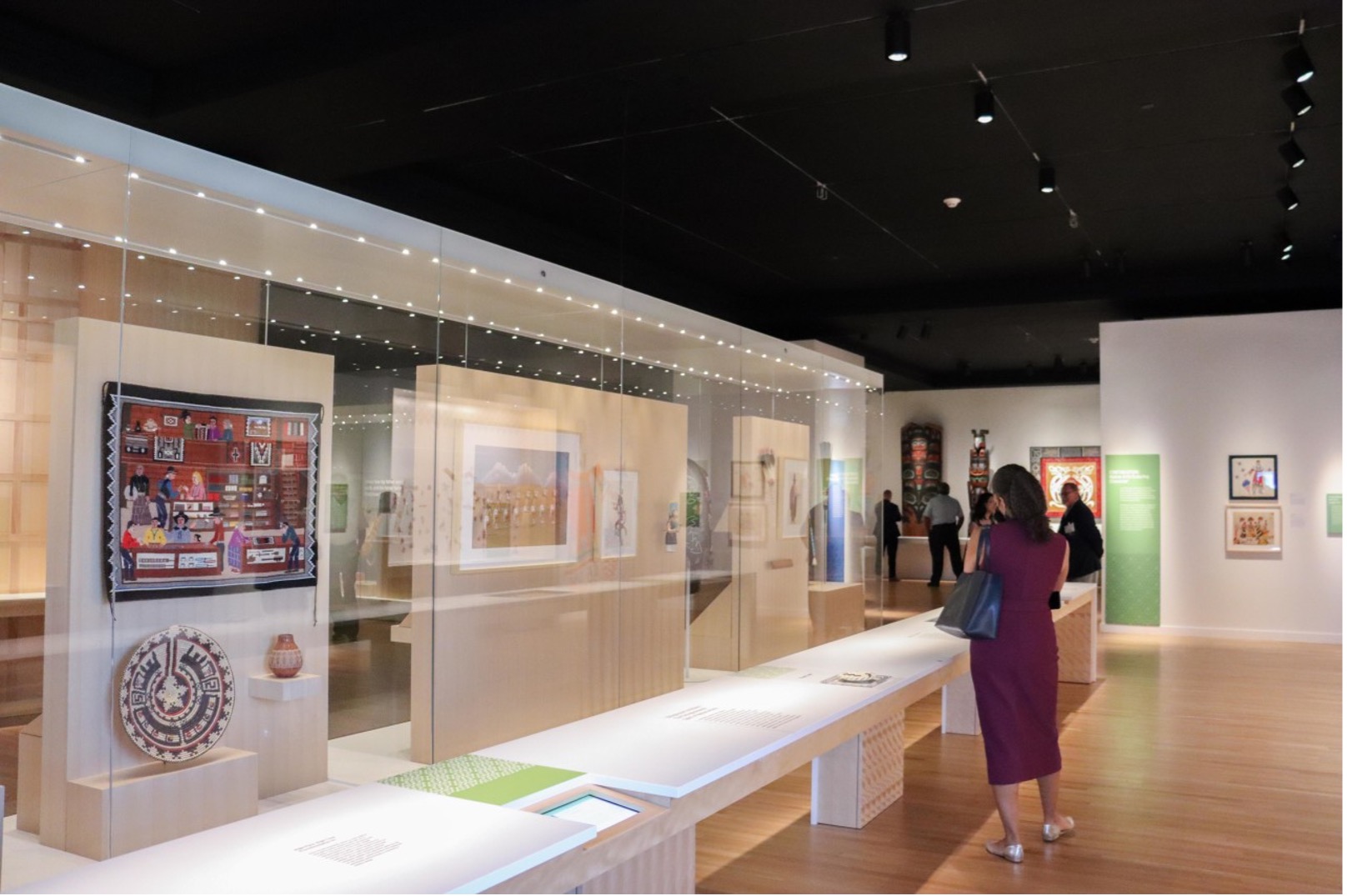 Visitors admire the renovated Eiteljorg Native American galleries, including textiles and art displayed in new glass cases.