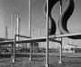 Black and white photo of pipes similar to those found in a power plant or oil refinery.