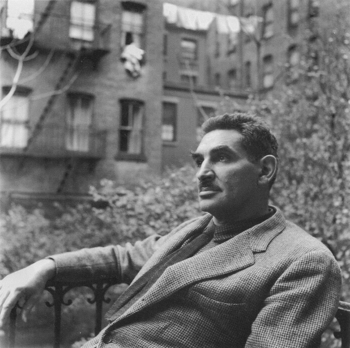 black and white photograph of a man with a mustache sitting 