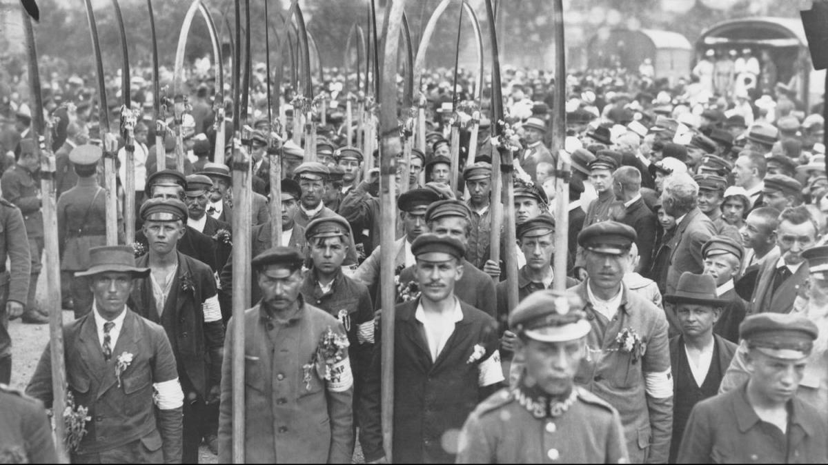 Black and white photo of armed Polish volunteers marching through Warsaw.