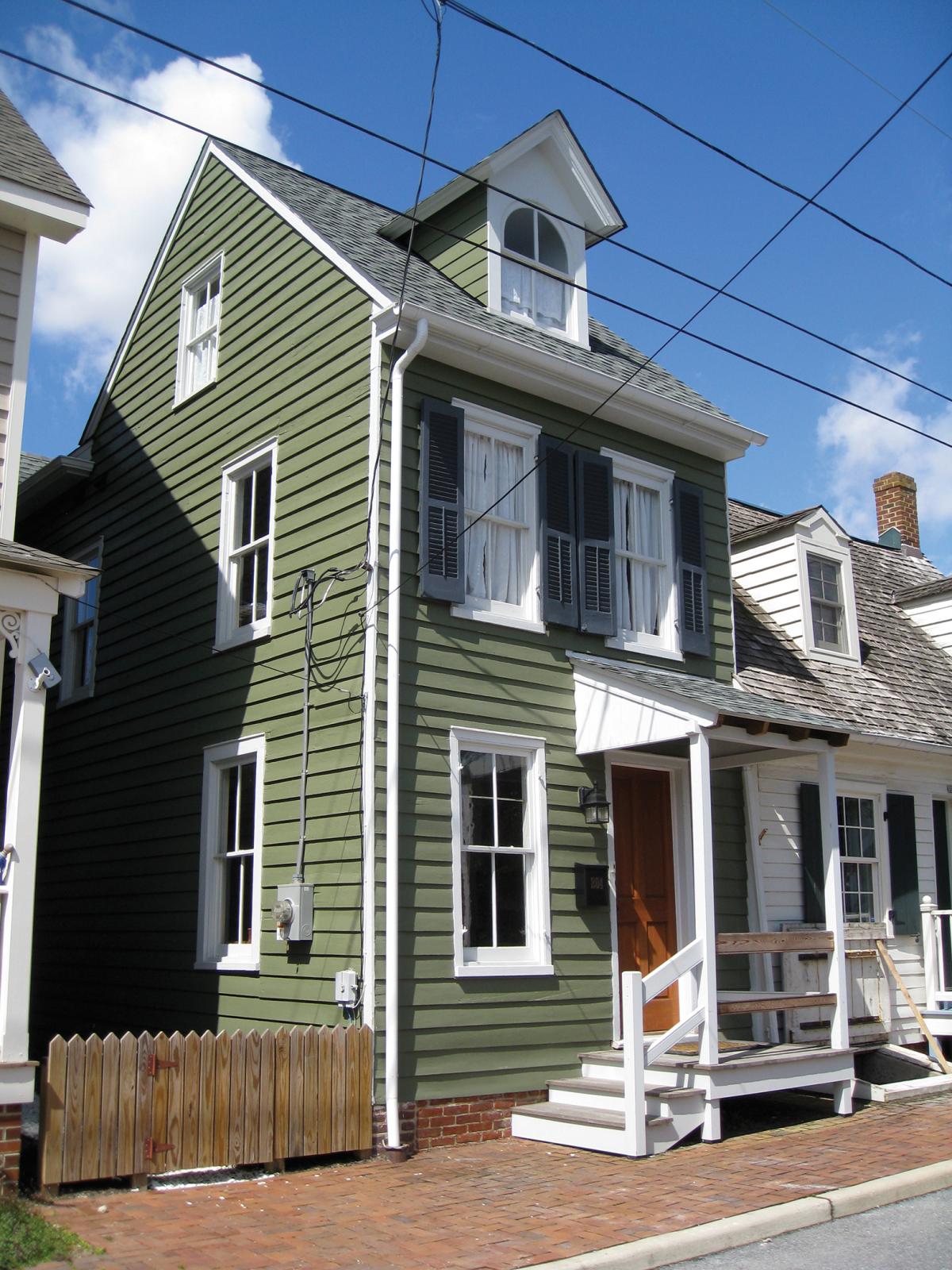 Photograph of facade of green rowhouse