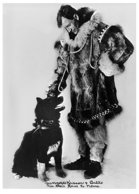 Black and white photo of a man looking down at a dog