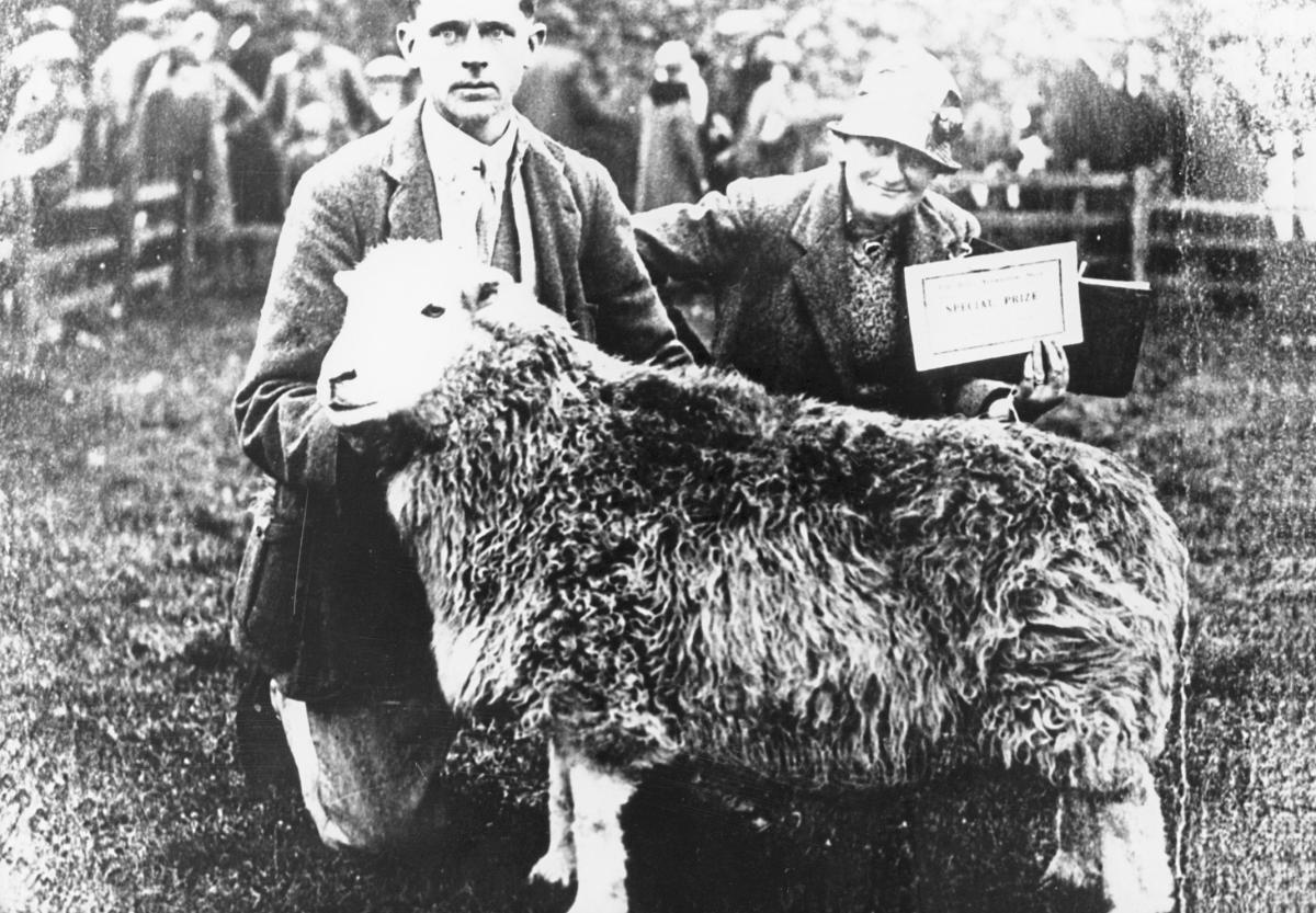 Beatrix Potter poses behind one of her prizewinning sheep.