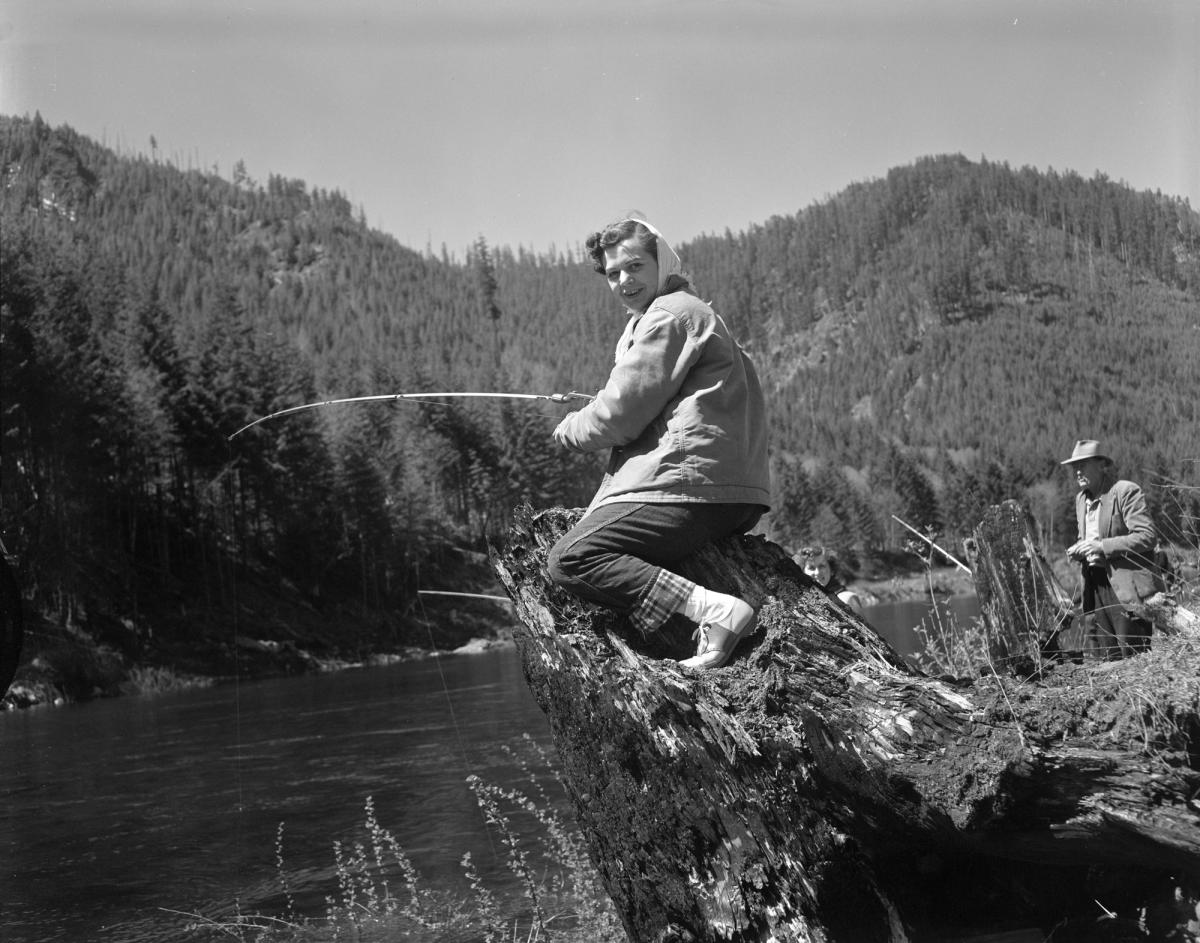 Black and white photograph of a woman fishing