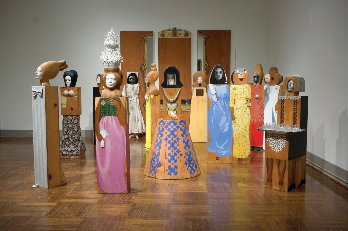 Marisol Escobar's artwork The Party, featuring wooden figures with replicated faces in dresses of different colors