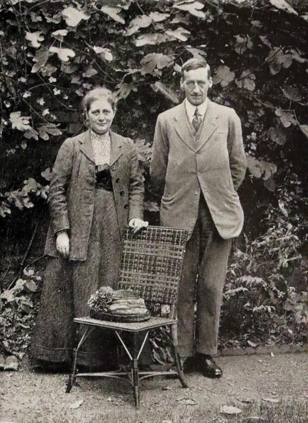 Black-and-white photo of Beatrix Potter standing next to her husband, William Heelis. 