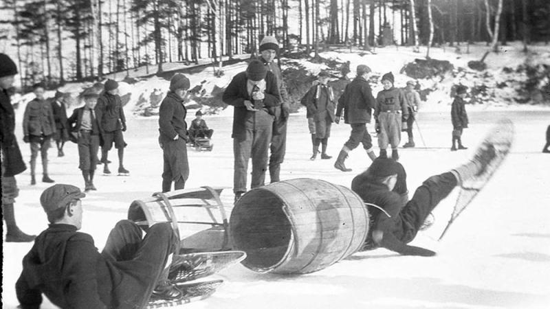 black and white photo of boys on a frozen pond