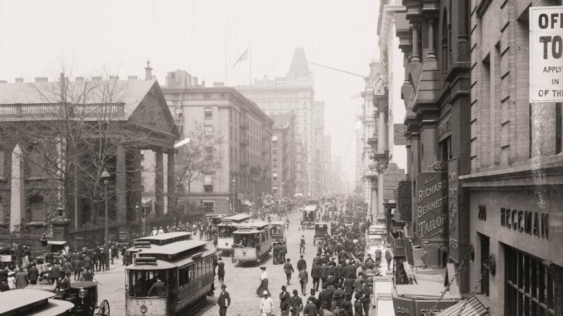 Black and white photograph of a busy city street, people on sidewalks