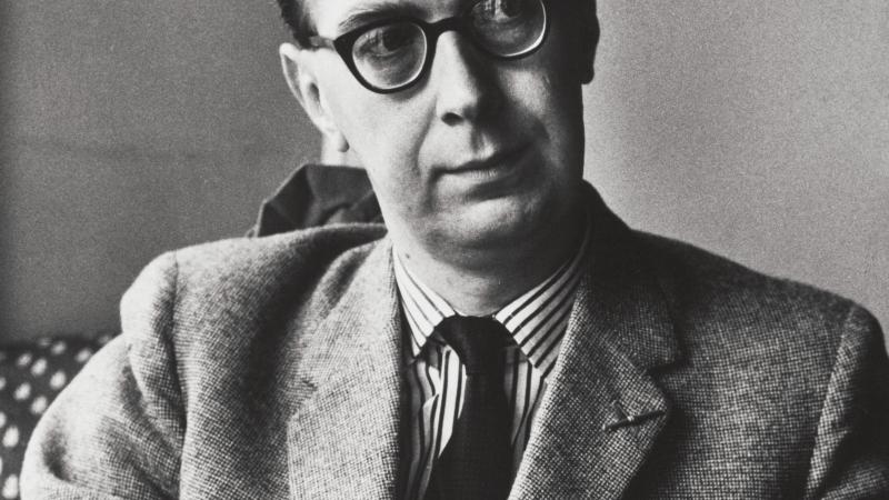 Philip Larkin, seated, looking thoughtful