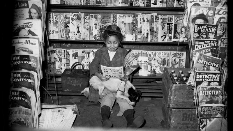 Girl reading in George Harris’s confectionary store by Charles 'Teenie' Harris.