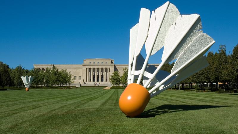 An image of the lawn of the Nelson Gallery of Art, with the building in the background and large statue of a shuttlecock in the foreground.